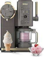 Ninja ice cream and frozen yogurt machine in dark gray and gold, shown with an ice cream cone and a bowl of pink frozen yogurt on a white background.